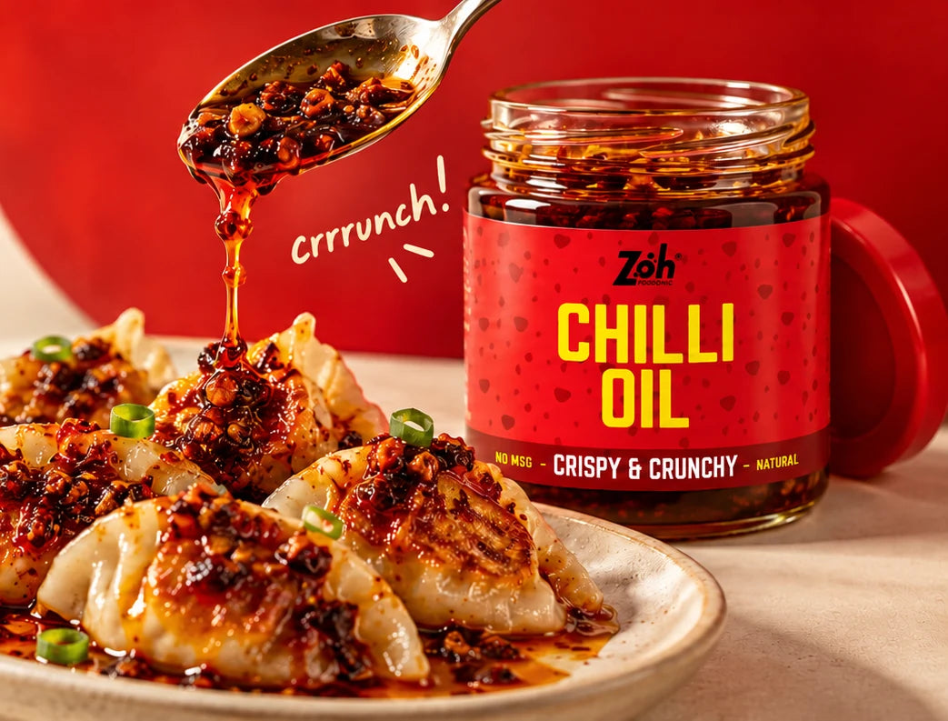 Zoh chilli oil jar and a spoon drizzling crispy chilli oil over dumplings